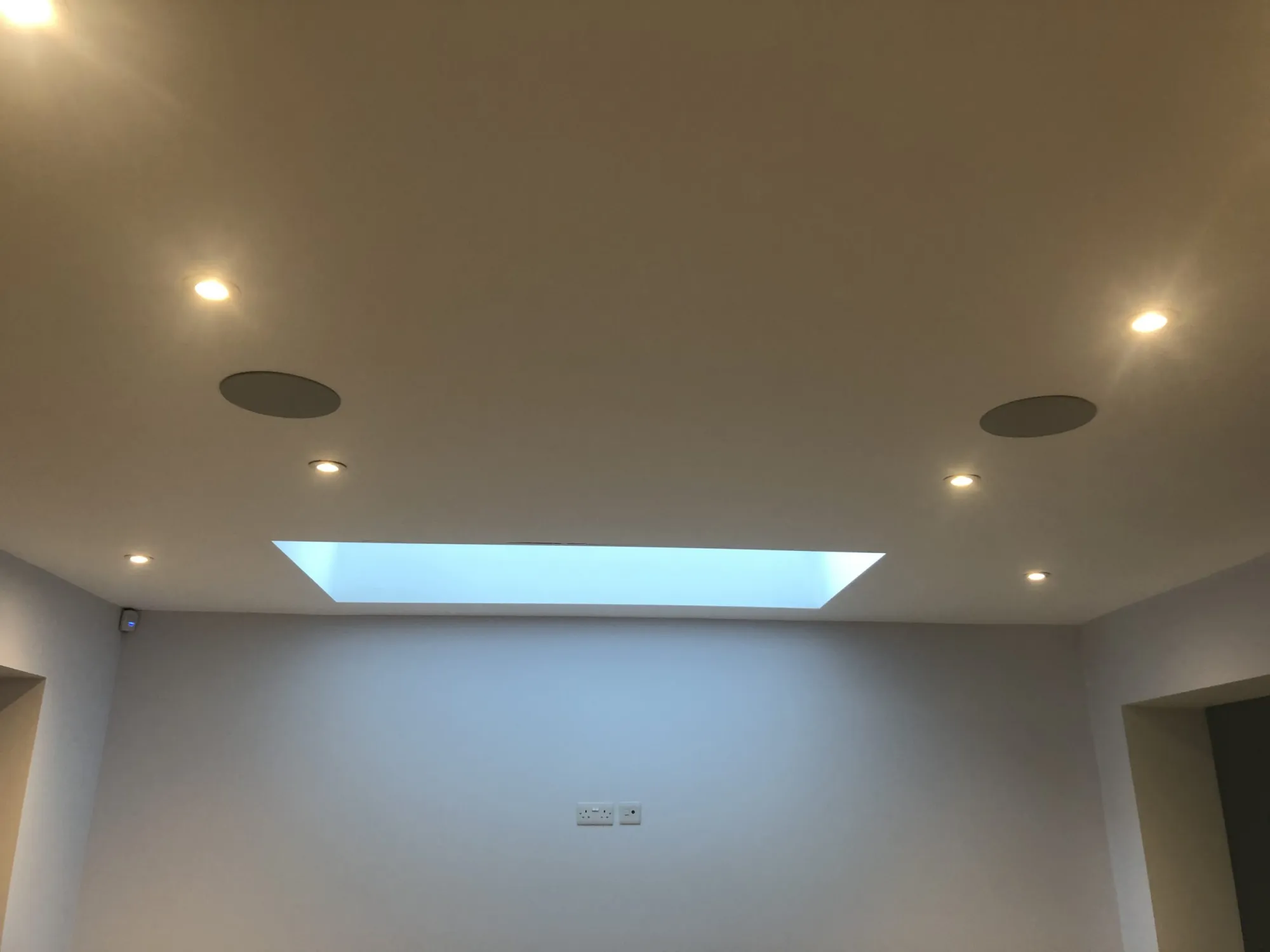 Large open-plan shop area with ceiling speakers and skylight, Essex retail AV